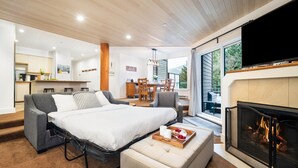 Een moderne slaapkamer met een groot bed, een televisie en een open haard.