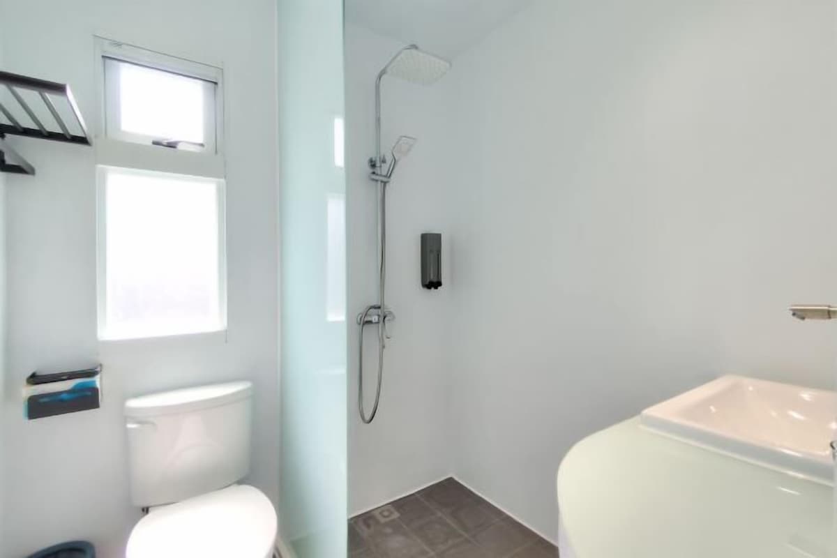A bathroom with a toilet, a shower, and a sink.