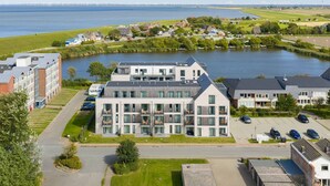 Un bâtiment moderne à plusieurs étages, doté de grandes fenêtres et d’un espace de stationnement à l’avant.