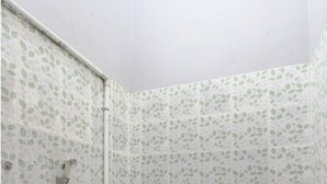 Ein Badezimmer mit Toilette, Dusche und Fliesenboden.