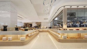 A modern hotel lobby with a central seating area and a kitchen visible through a glass partition. - Gamalan Star Hotel (Yilan)