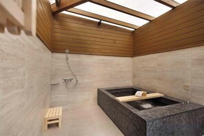 A modern bathroom with a skylight, a bathtub, and a shower area. - Gamalan Star Hotel (Yilan)