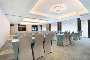 A conference room with rows of tables and chairs, a chandelier, and large windows. - Gamalan Star Hotel (Yilan)