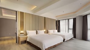 A modern hotel room with two beds, a wooden floor, and a large window with curtains. - Gamalan Star Hotel (Yilan)