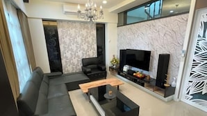 Ein modernes Wohnzimmer mit Ecksofa, Couchtisch, Fernseher und Wanddekoration.