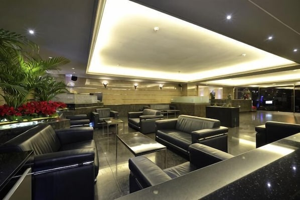 A modern lobby with leather seating, a reception desk, and a large plant. - Hi-YES HOTEL TAOYUAN (Taoyuan)