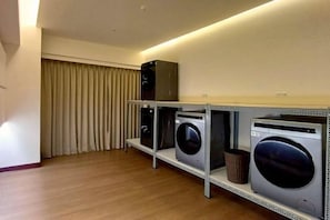 A laundry area with a washing machine, dryer, and stacked washer-dryer unit. - Hi-YES HOTEL TAOYUAN (Taoyuan)