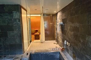 Ein Badezimmer mit Badewanne, Dusche und Handtuchhalter.