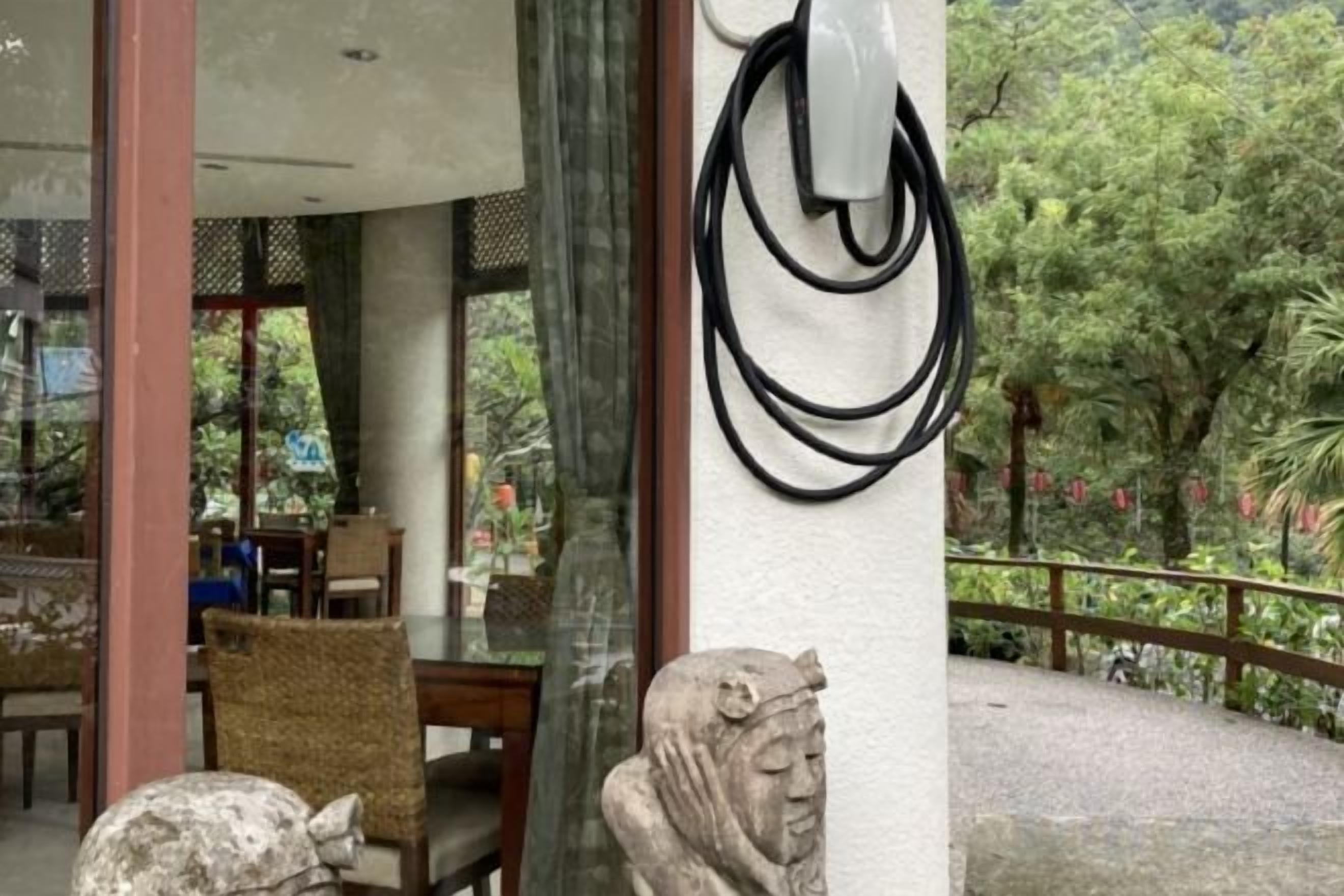 A stone statue and a metal sculpture on a building's exterior.