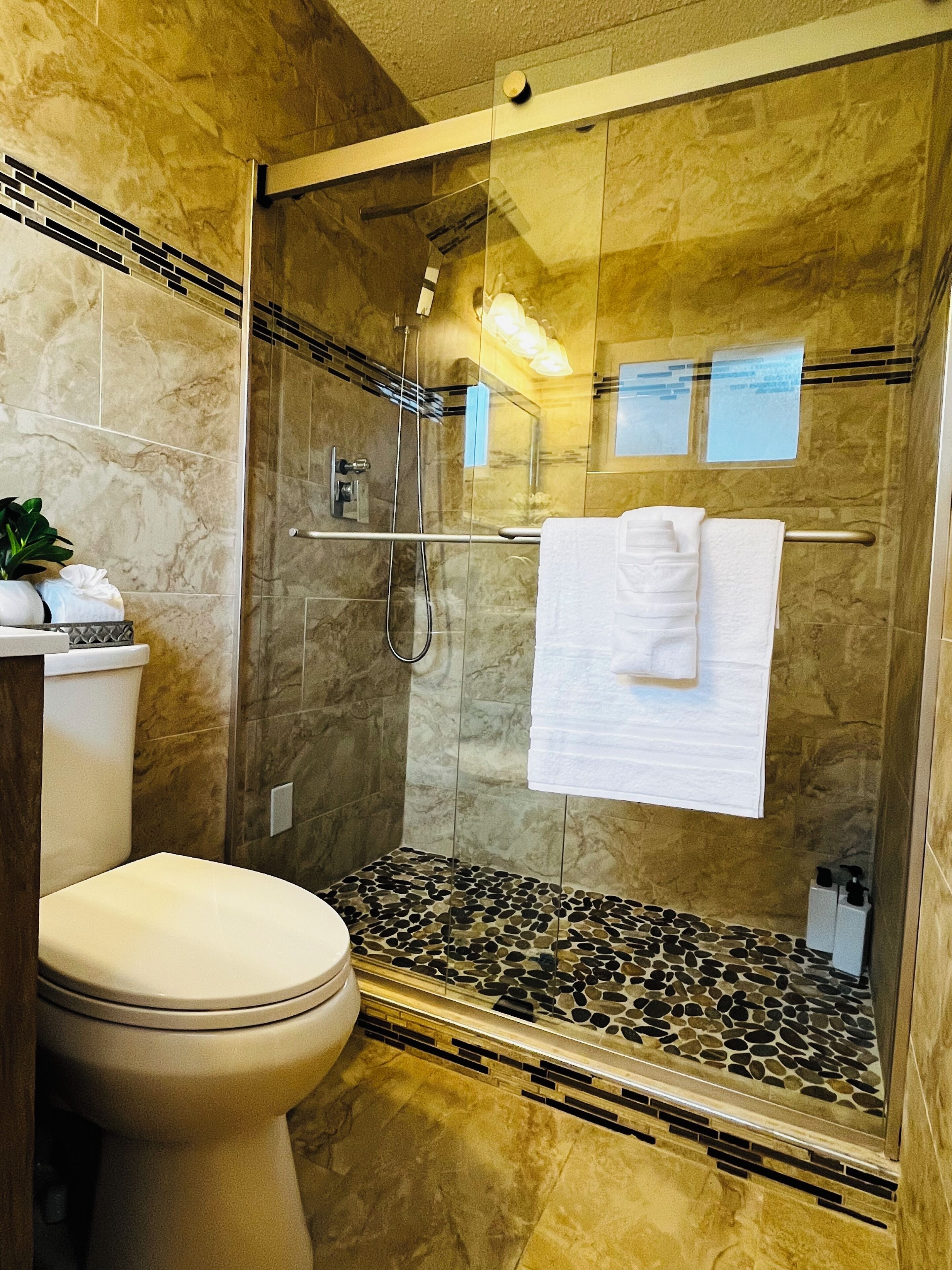 Een douche, handdoeken, zeep, shampoo