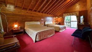Una cabaña de madera con dos camas, un escritorio, una silla y una ventana.