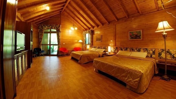 Un interior de madera con dos camas, televisor y comedor.