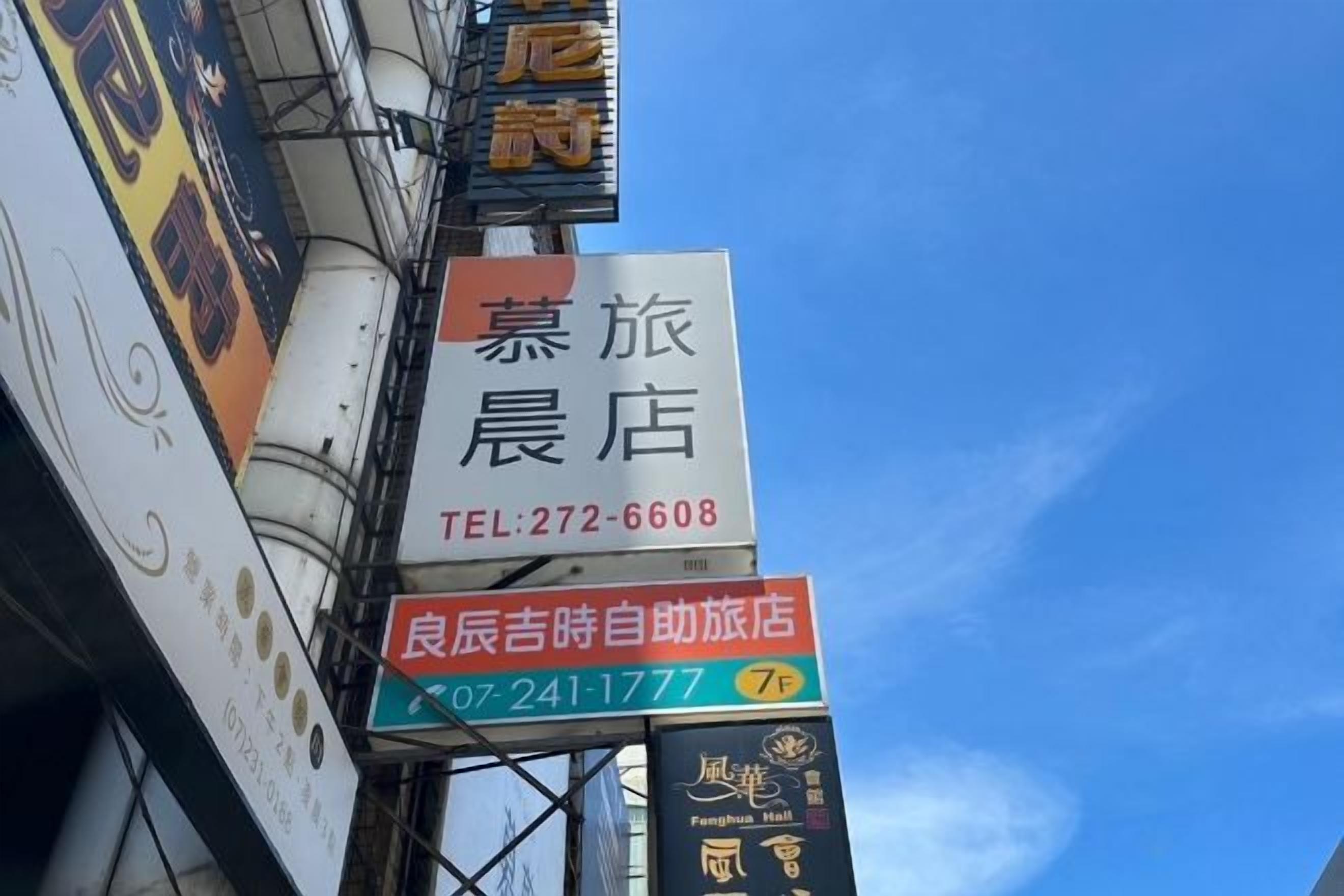 A hotel sign with Chinese characters and a contact number.