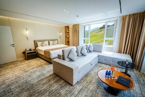 Een hotelkamer met een bed, een bank en een kleine tafel met een vaas en een boek.