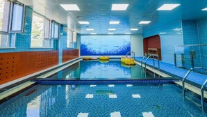 An indoor swimming pool with clear blue tiles, a central lane, and a large window with a view of the sky. - Juulchin Terelj Resort (Ulaanbaatar)