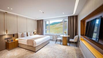 Habitación de hotel moderna con una cama grande, un escritorio y vistas a un paisaje.