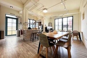 Una cocina amplia con una isla grande, suelo de madera y un comedor con sillas y una mesa.