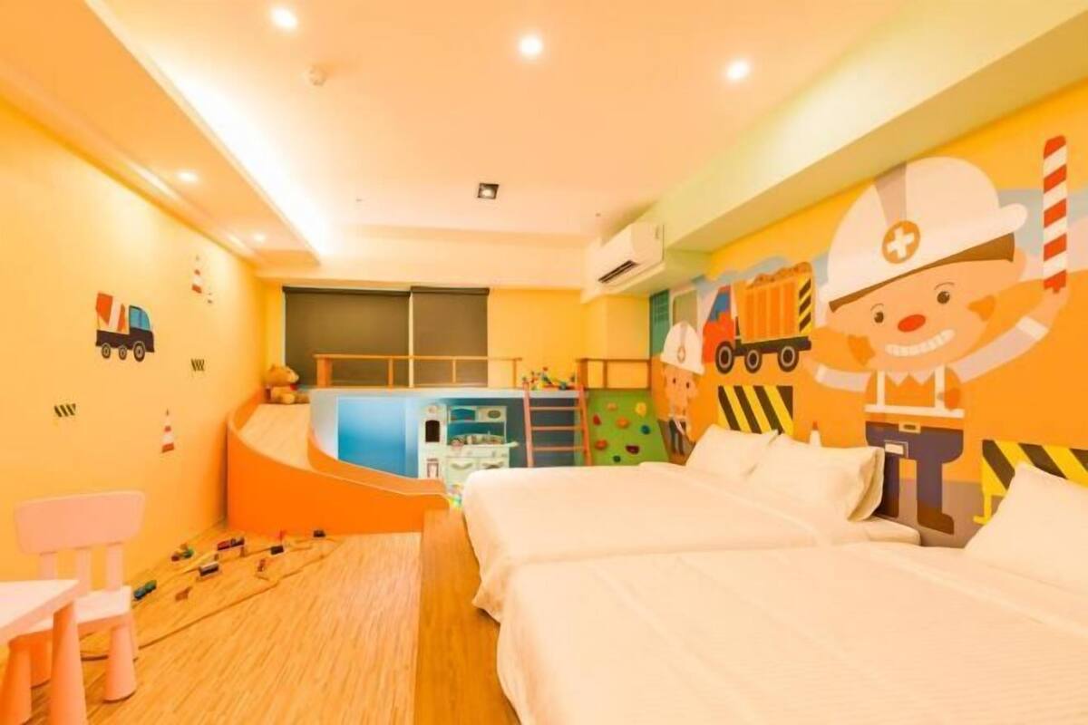 A children's room with bunk beds, a play area, and a wall mural.