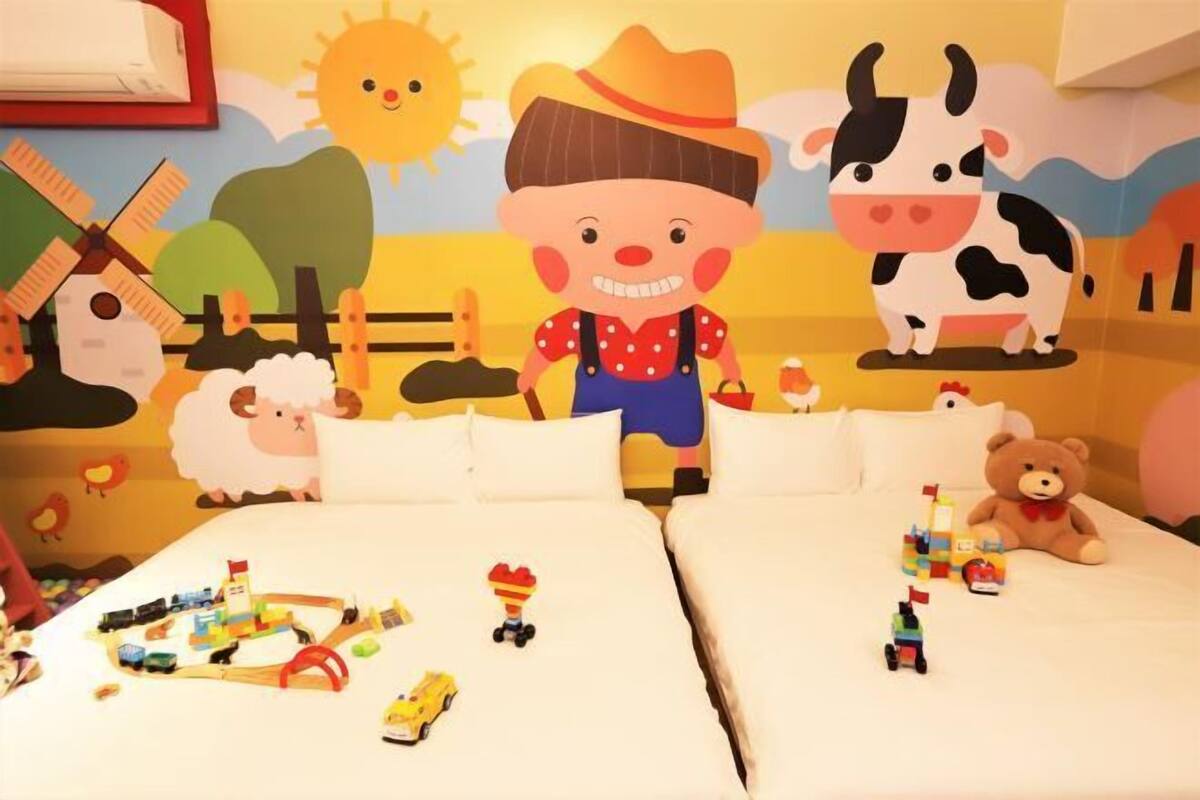A children's room with two beds, a large mural of farm animals, and toys scattered on the beds.