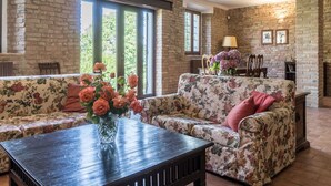 A cozy living room with a sofa, a wooden table, and a vase of flowers.
