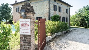 A stone building with a sign for 'Tabiano Castello Country Villas Ca' de Angeli'.