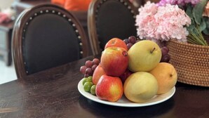 A dining table with a plate of fruits and a basket of flowers. - Le Soleil Ba vi (Hanoi)
