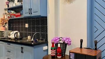 Une cuisine avec des armoires bleues, un comptoir noir et une guirlande décorative accrochée au mur.
