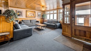 A cozy lobby with wooden paneling, a reception desk, and a large wooden door. - Double room river view (Québec)