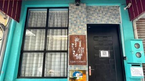 A building facade with a large window, a door with a QR code, and a sign with Japanese characters. - Iron shop Fuqiankan (Tainan)
