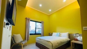 A bedroom with a bed, a chair, a nightstand, a window with curtains, and a television mounted on the wall. - Iron shop Fuqiankan (Tainan)