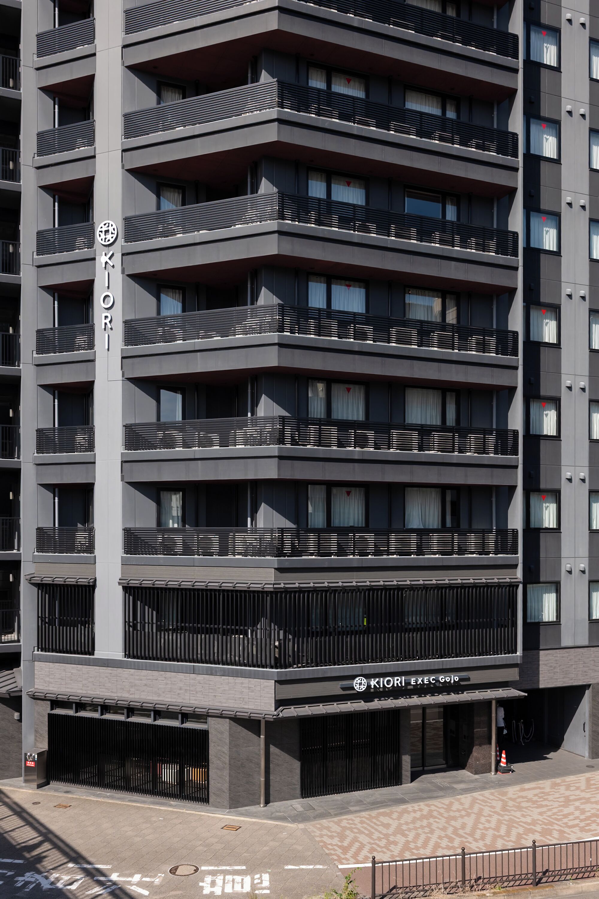 A multi-story building with balconies and a sign that reads "KIORI EXEC GO".