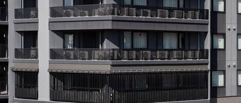Un edificio de varios pisos con balcones y un letrero que dice 'KIORI EXEC GO'.