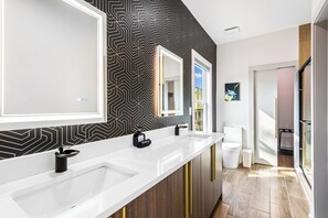 A modern bathroom with two sinks, a large mirror, and a patterned wall. - The Groove House: Stylish Atlanta Escape (Atlanta)