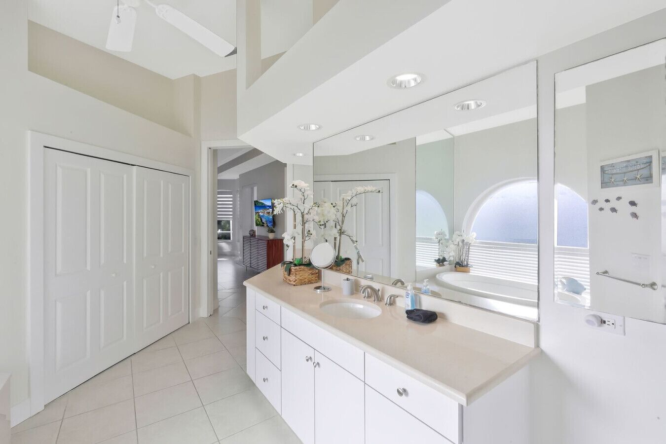 A modern bathroom with a large vanity, a double sink, and a large mirror.