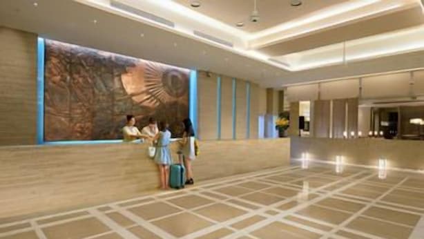 A hotel lobby with a large wall mural, a reception desk, and a tiled floor. - Century Hotel (Taitung)
