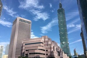 Un paisaje urbano con modernos rascacielos, incluyendo una destacada torre con un diseño singular.