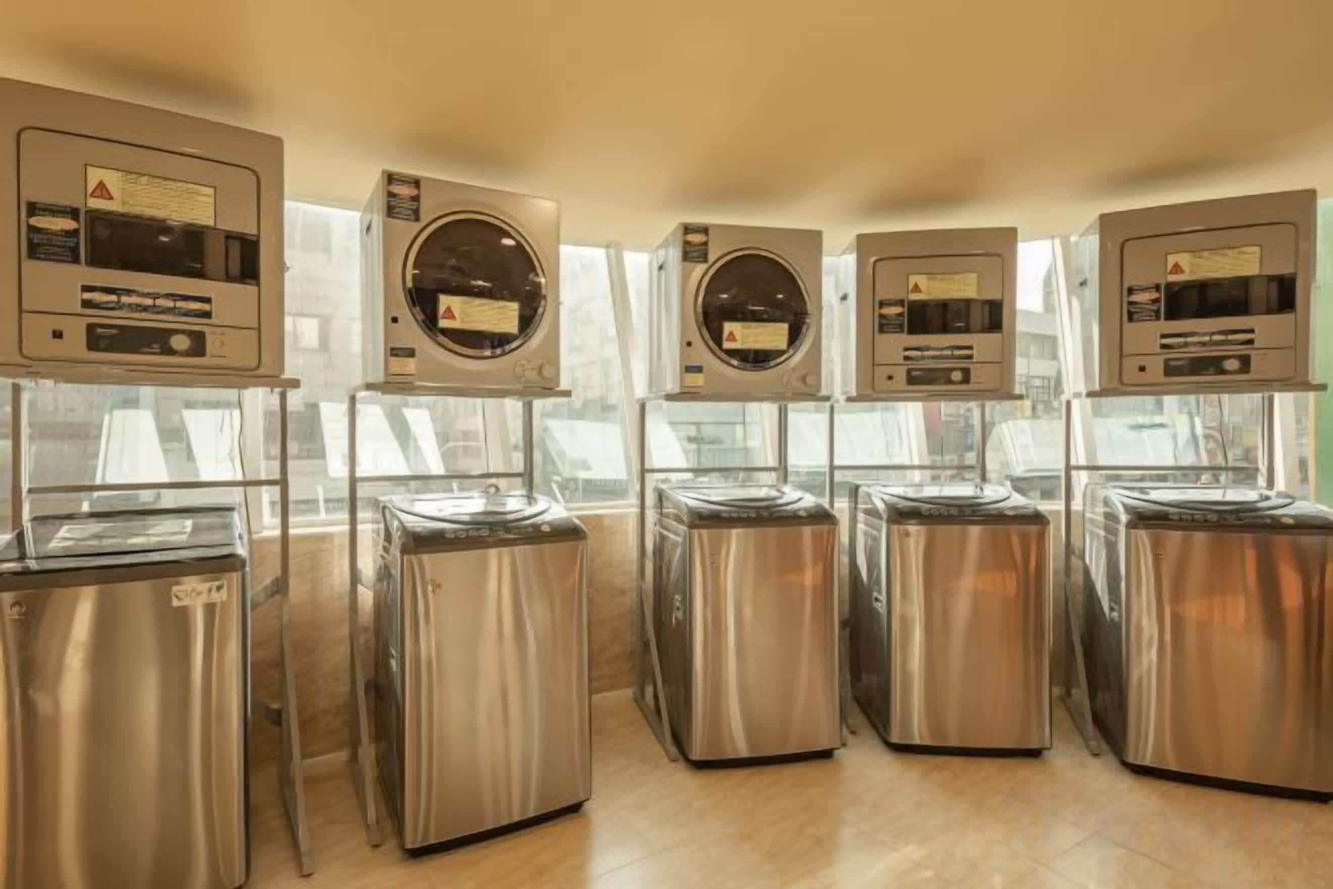 A row of self-service beverage dispensers with control panels, arranged in a row on a wooden floor.