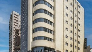 Un edificio de varios pisos con fachada curva y ventanas grandes.