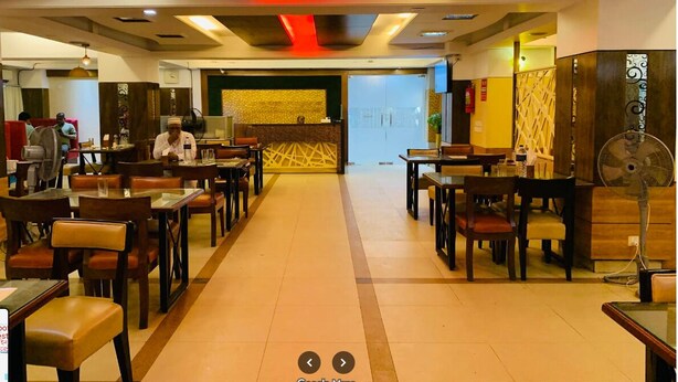 Un ristorante con un bancone centrale, diversi tavoli e sedie.