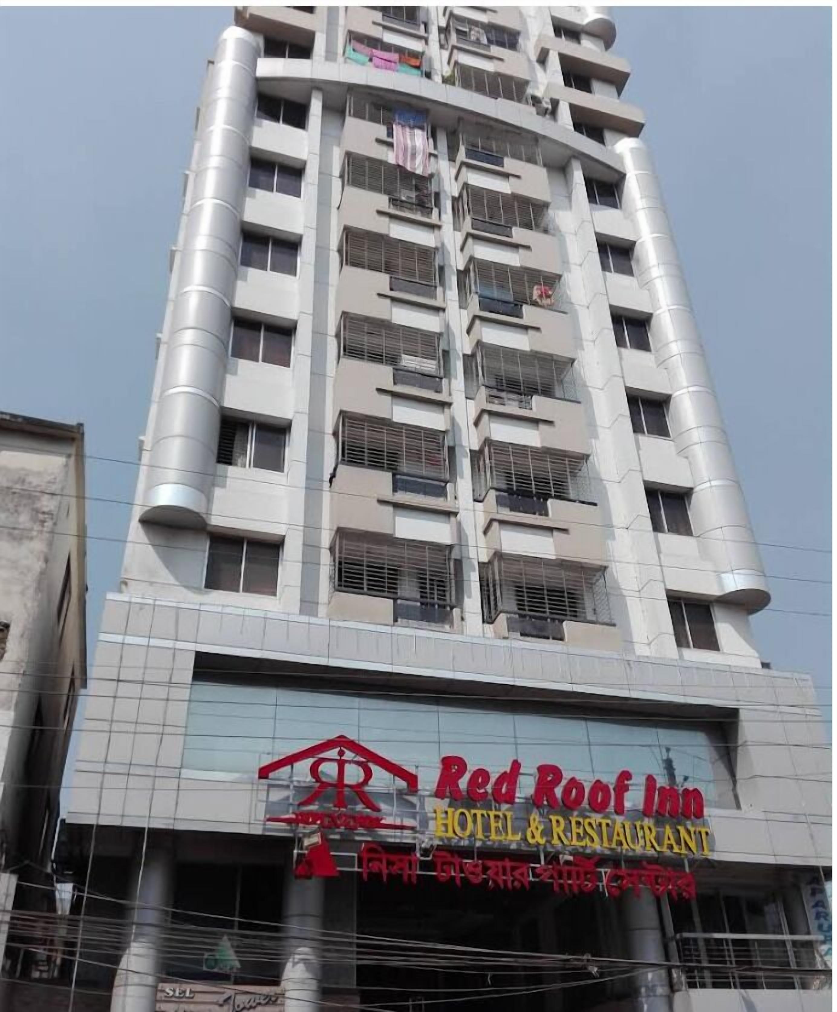 Um edifício alto com uma placa indicando Red Roof Inn Hotel & Restaurant.