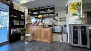 A modern interior with a wooden reception desk, shelves with various items, and a large painting on the wall. - Bantshiann Hualie Hotel (Hualien)