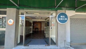 A hotel entrance with a glass door, a signboard, and a metal shutter. - Bantshiann Hualie Hotel (Hualien)