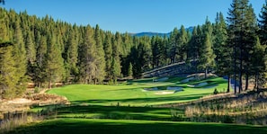 A golf course with sand bunkers, surrounded by dense forest and mountains. - Basecamp Luxury Truckee retreat in Grays Crossing (Truckee)