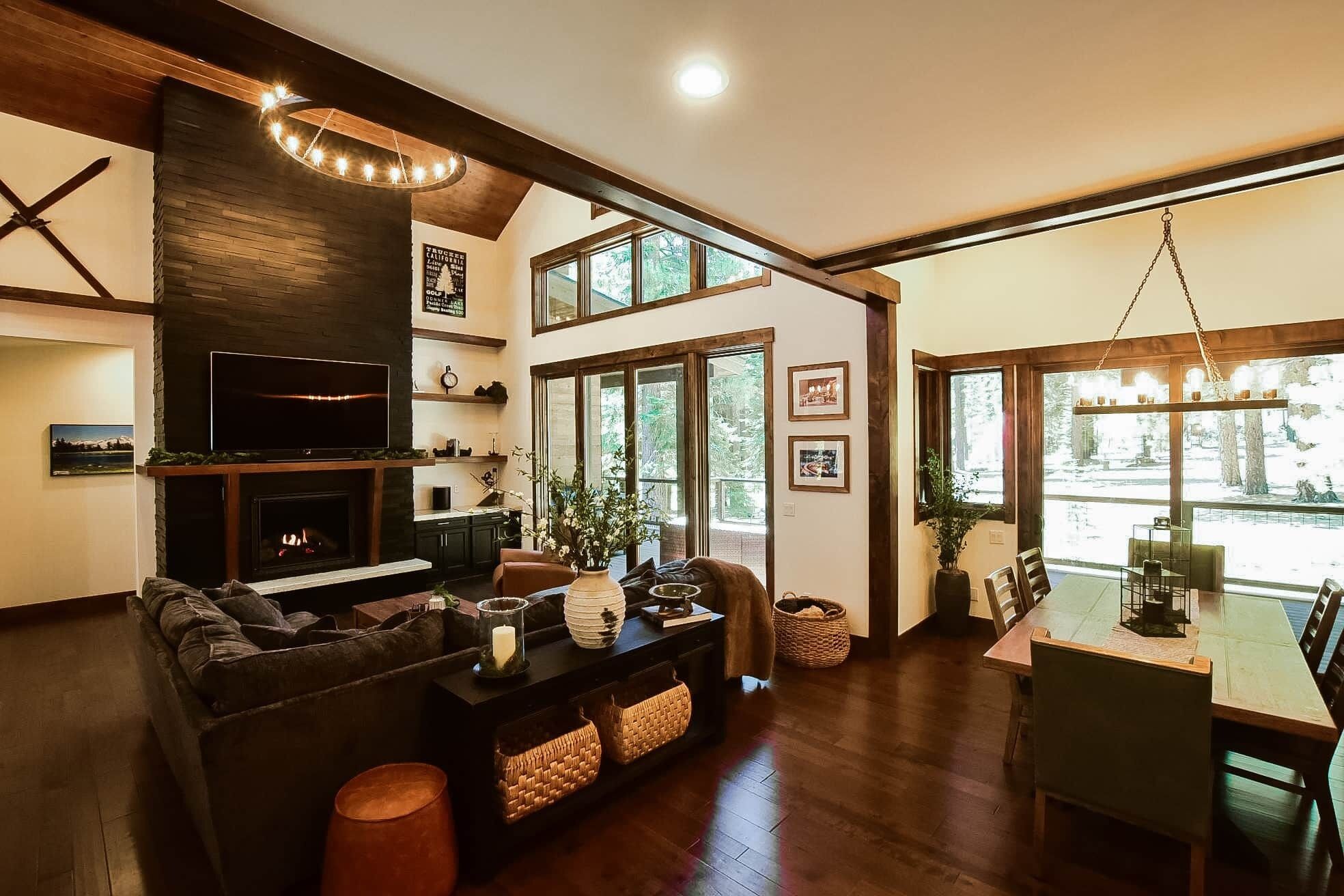 A spacious living area with a fireplace, a television, and a dining table with chairs.