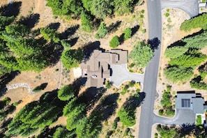 An aerial view of a residential area with a house surrounded by trees and a road. - Basecamp Luxury Truckee retreat in Grays Crossing (Truckee)