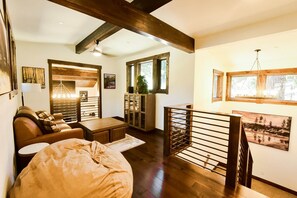 Ein gemütliches Wohnzimmer mit einer Couch, einem Couchtisch und einer Holztreppe.