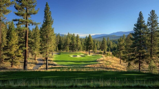 A golf course with a clear path, surrounded by tall pine trees and distant mountains. - Grays Crossing Luxury Cabin w/ Spa & Putting Green (Truckee)