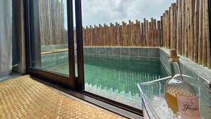 A room with a large window overlooking a pool, a wooden fence, and a bottle of Freixenet Italian Rose wine on a table. - MHV Milagres - Guadalupe 11 (Passo de Camaragibe)