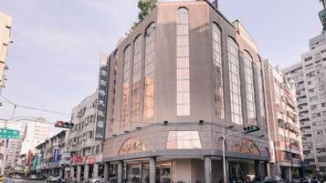 A multi-story hotel with a curved facade, large windows, and a ground-level entrance.
