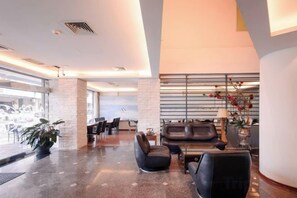 A modern lobby with a seating area, a reception desk, and a large window. - Waughden Business Hotel (Taichung)